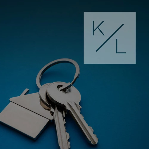Silver house-shaped keychain with keys on a dark blue gradient background
