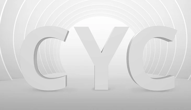 Three-dimensional white letters spelling CYC on a white curved-arch backdrop with concentric rings