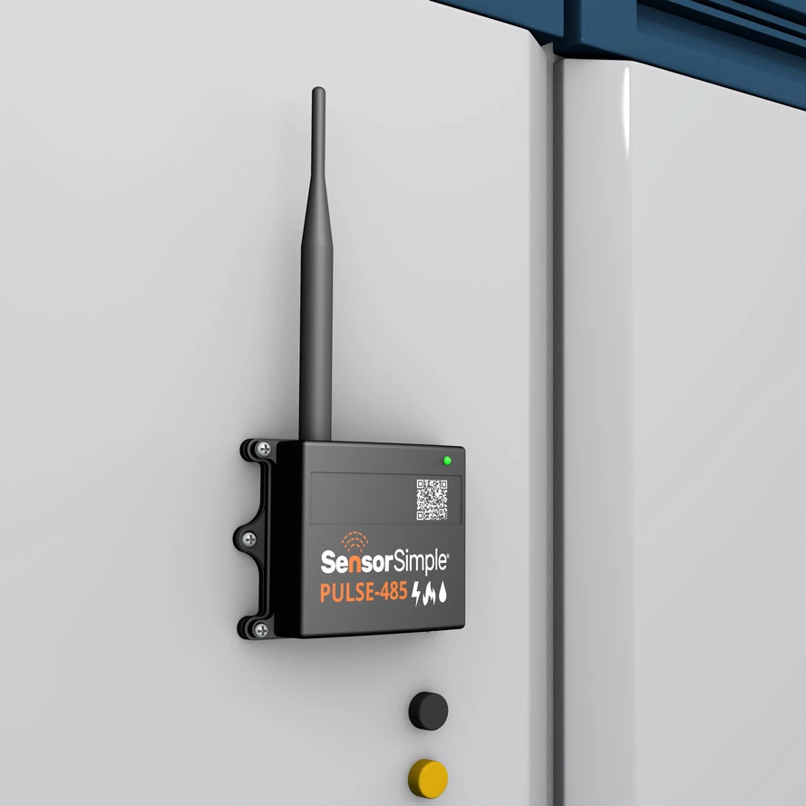 SensorSimple PULSE-485 black wireless sensor module with antenna mounted on a white industrial cabinet