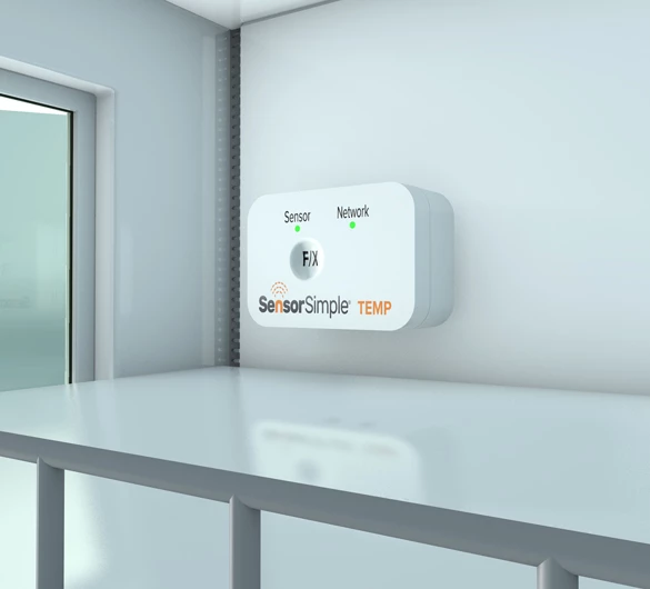 SensorSimple TEMP wall-mounted temperature sensor device on a light gray wall beside a window and metal shelving