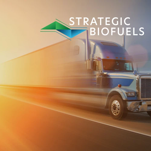 Blue semi truck speeding down a sunlit highway with motion blur, Strategic Biofuels logo and wordmark in the upper right